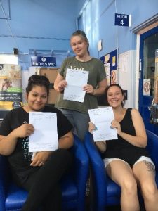 three people receiving their gcse results and smiling