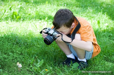 Young boy photographing wild mushrooms