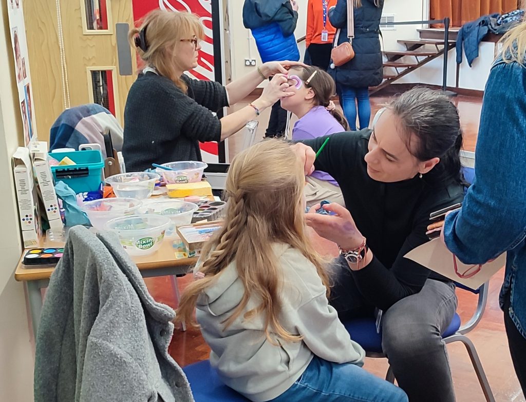 Children on Chairs getting their faces painted