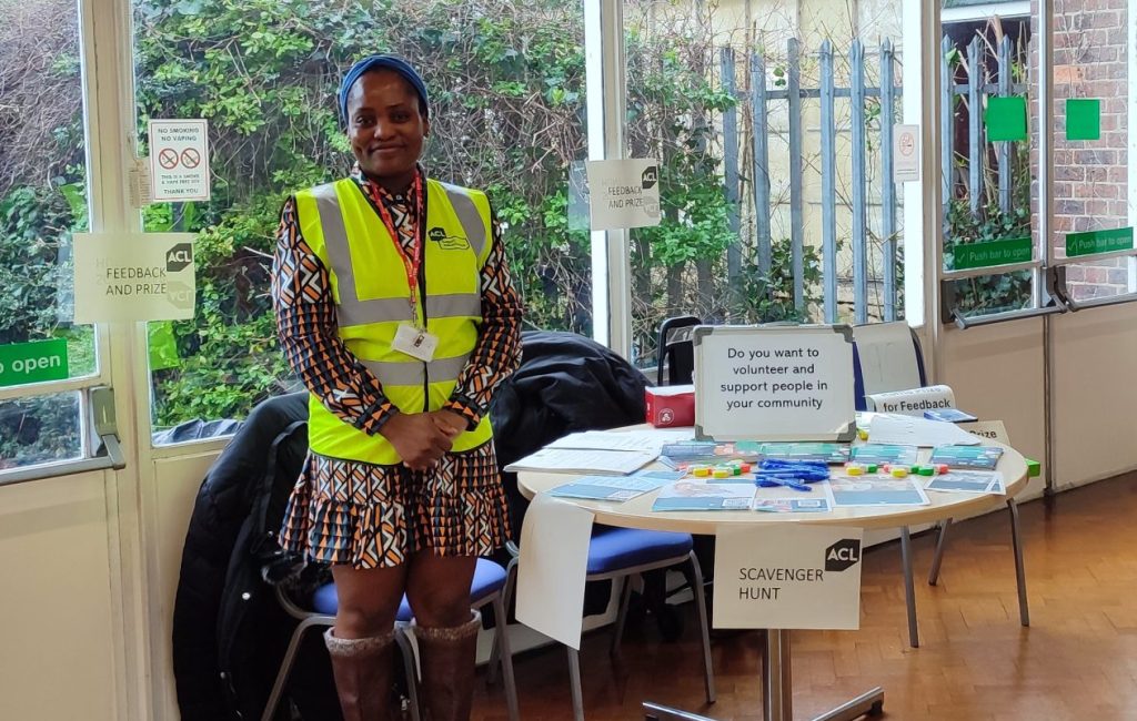 Woman standing next to a table with leaflets on