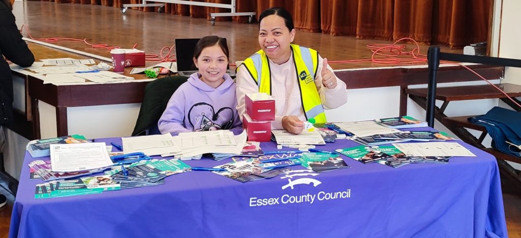 Woman Sitting at a desk with her daughter with leaflets on